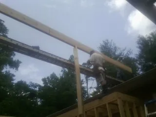 Carpenter setting a ridge beam over a new addition frame — Ice Dam Removal by Roofing Brothers in Rensselaerville