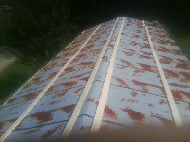 Rusted metal roof panels with new wood purlins before replacement — Storm Damage Roof Repair in Rensselaerville by Roofing Brothers