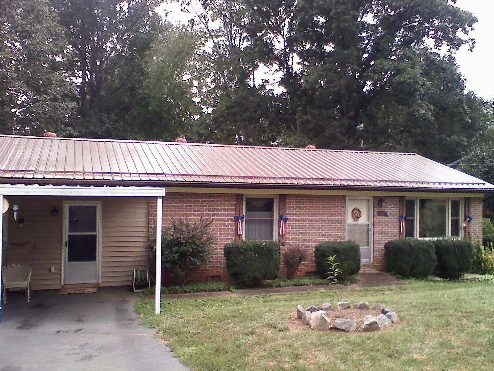 Bronze metal roof and carport on a brick ranch home — Roof Repair work by our crew in Rensselaerville